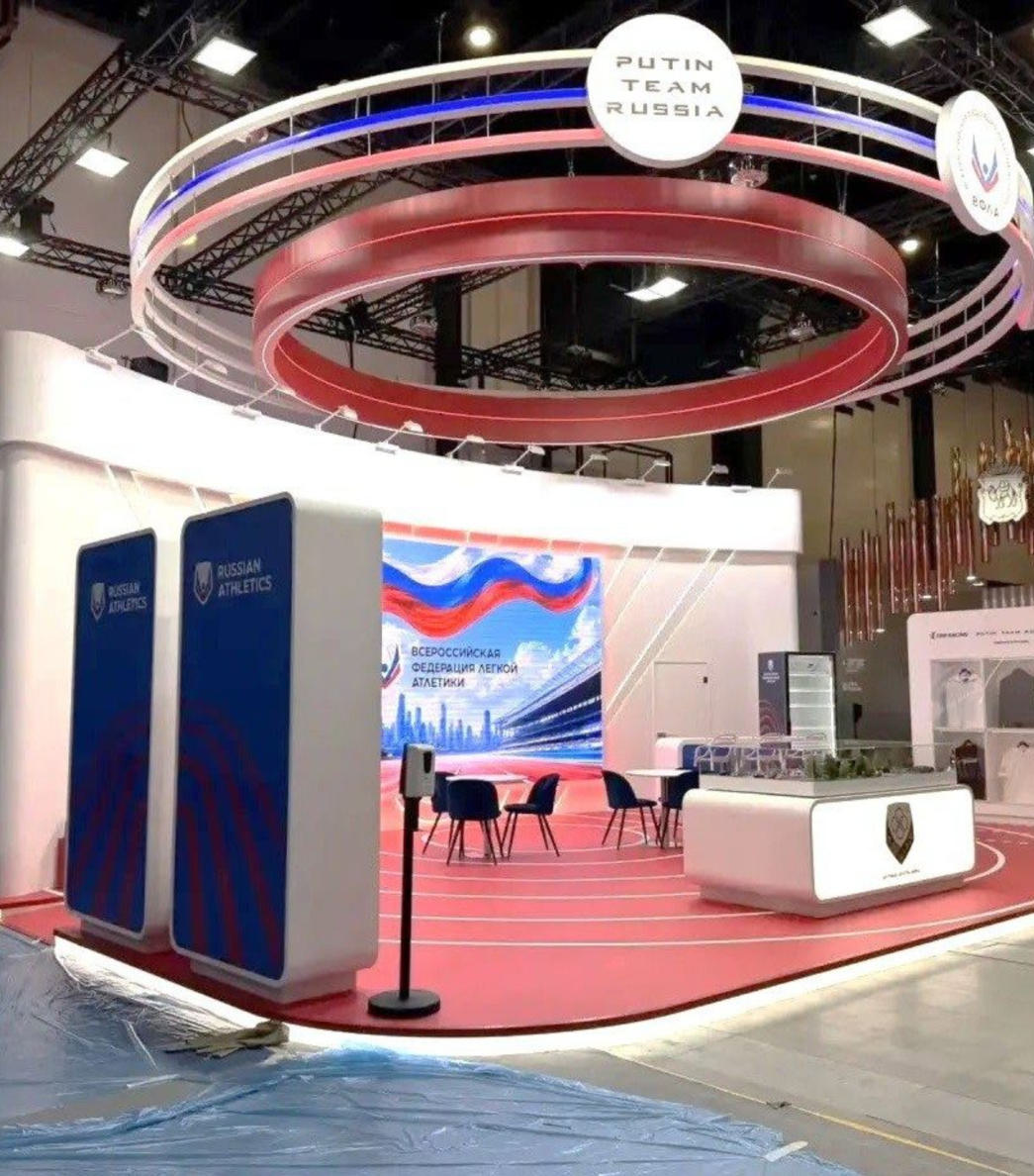 Стенд Всероссийской федерации лёгкой атлетики на ПМЭФ 2026 с круговой конструкцией и беговой дорожкой в полу